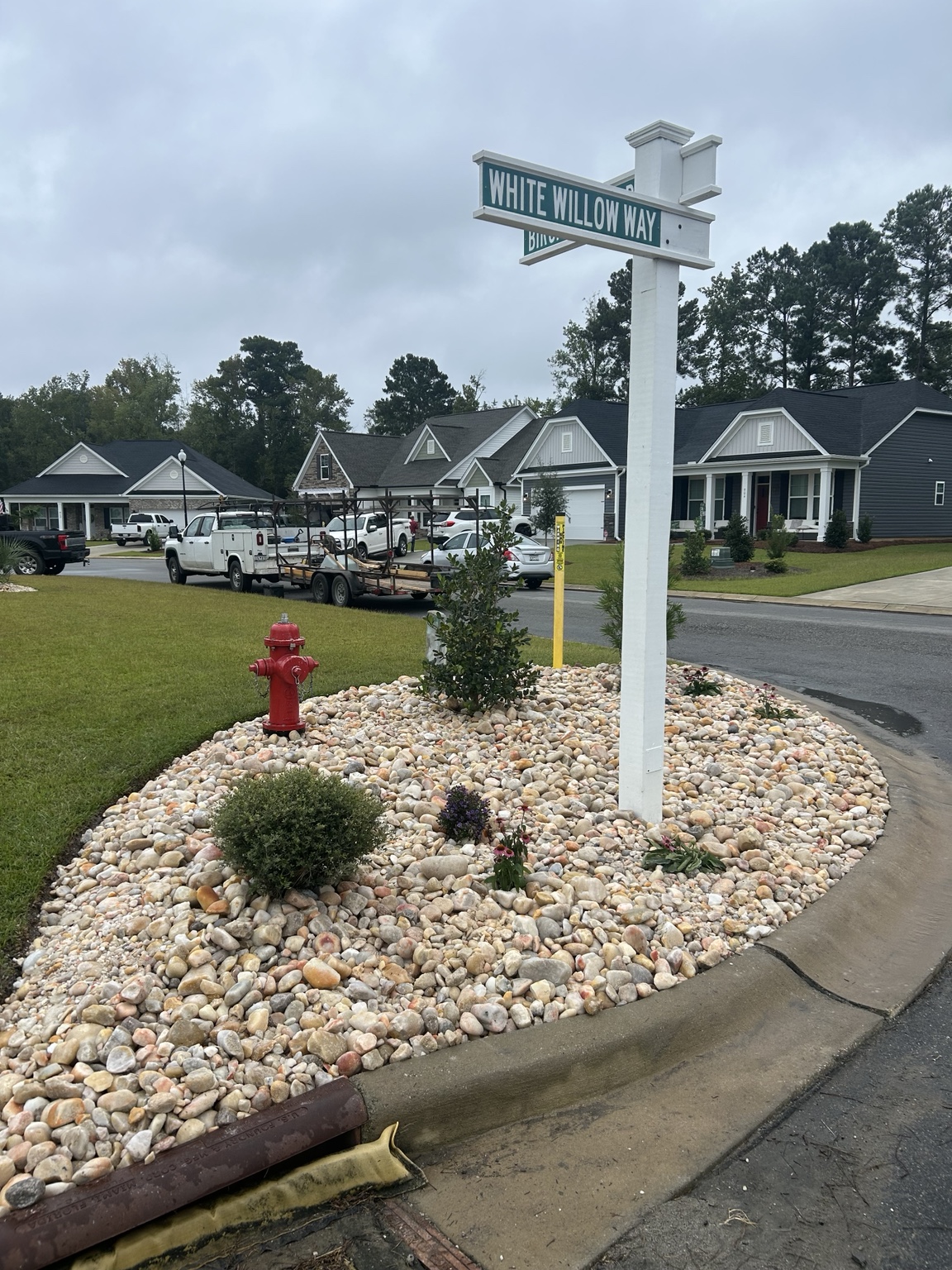 Completed 2 to 5 inch Carolina River Rock landscape bed around a neighborhood entrance sign